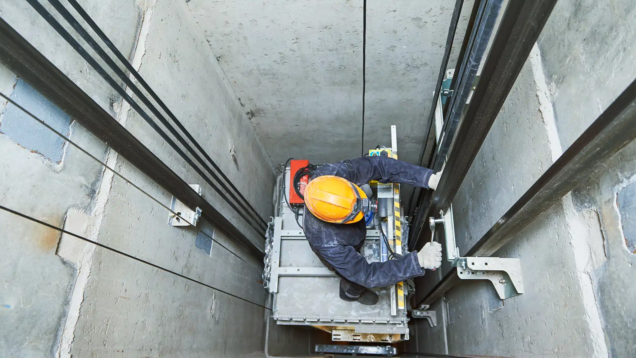 Island Elevator Repair - Lift Machinist Repairing Elevator in Lift Shaft